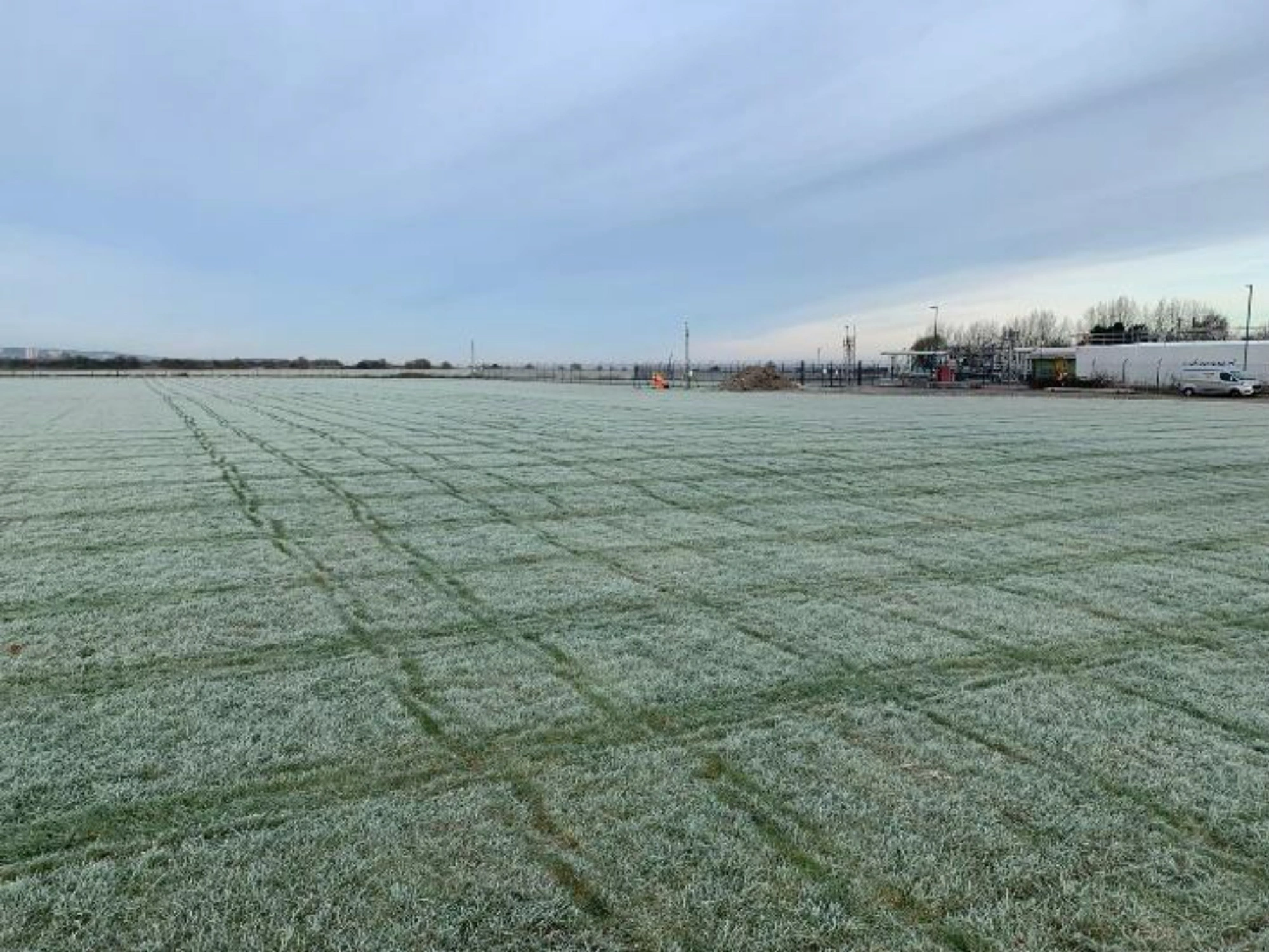 A large expanse of frosty grass below a cloudy sky on site at Uniper Energy.