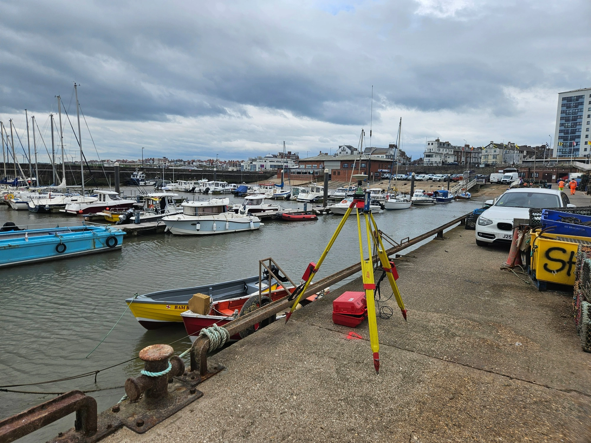 A wide show of Bridlington Harbour with various boats in the water and survey equipment positioned on the edge of the harbour.