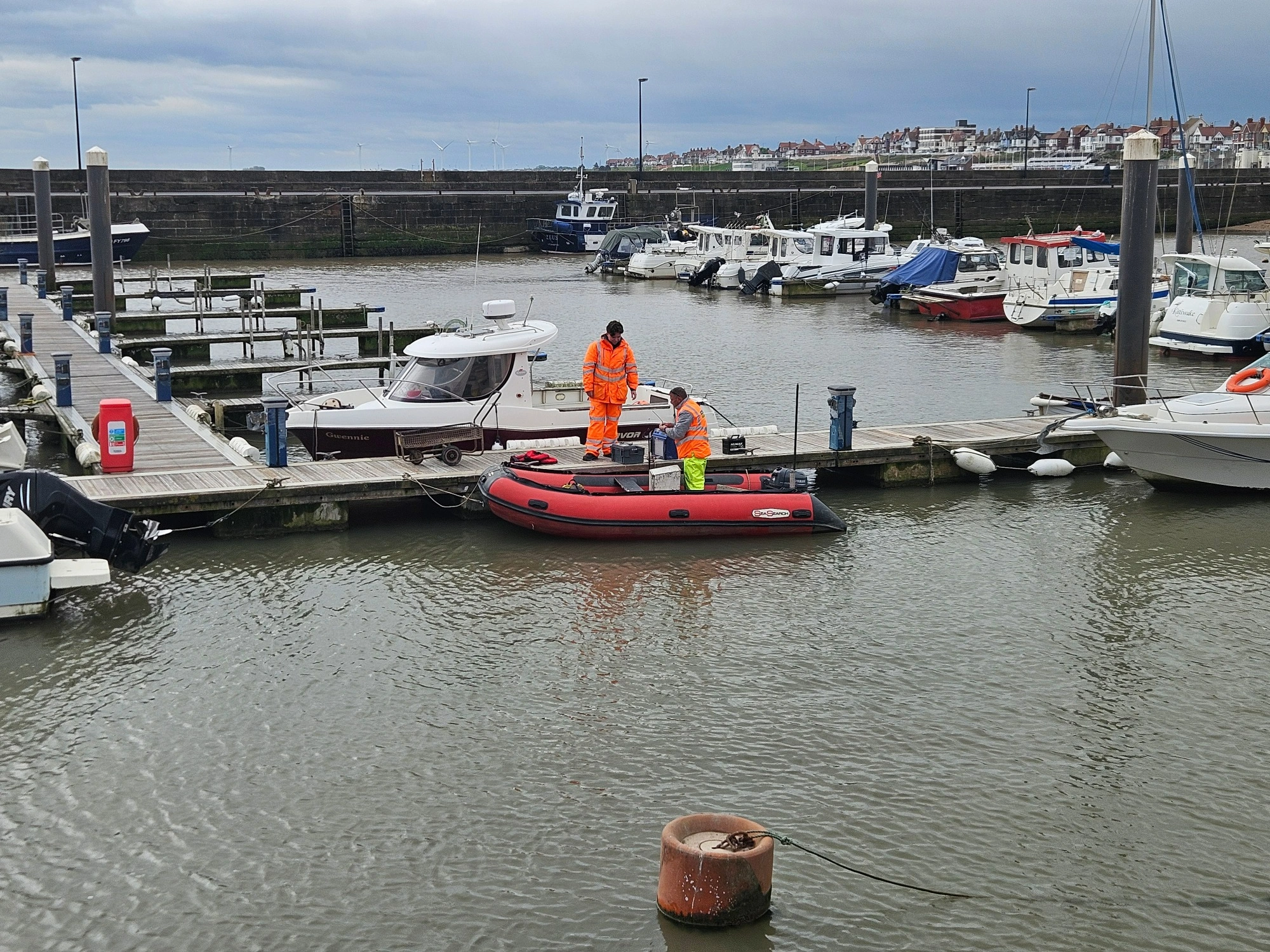 MHLS-bridlington-harbour-case-study (1)-3 MHLS land surveyors in an orange boat on Bridlington Harbour.