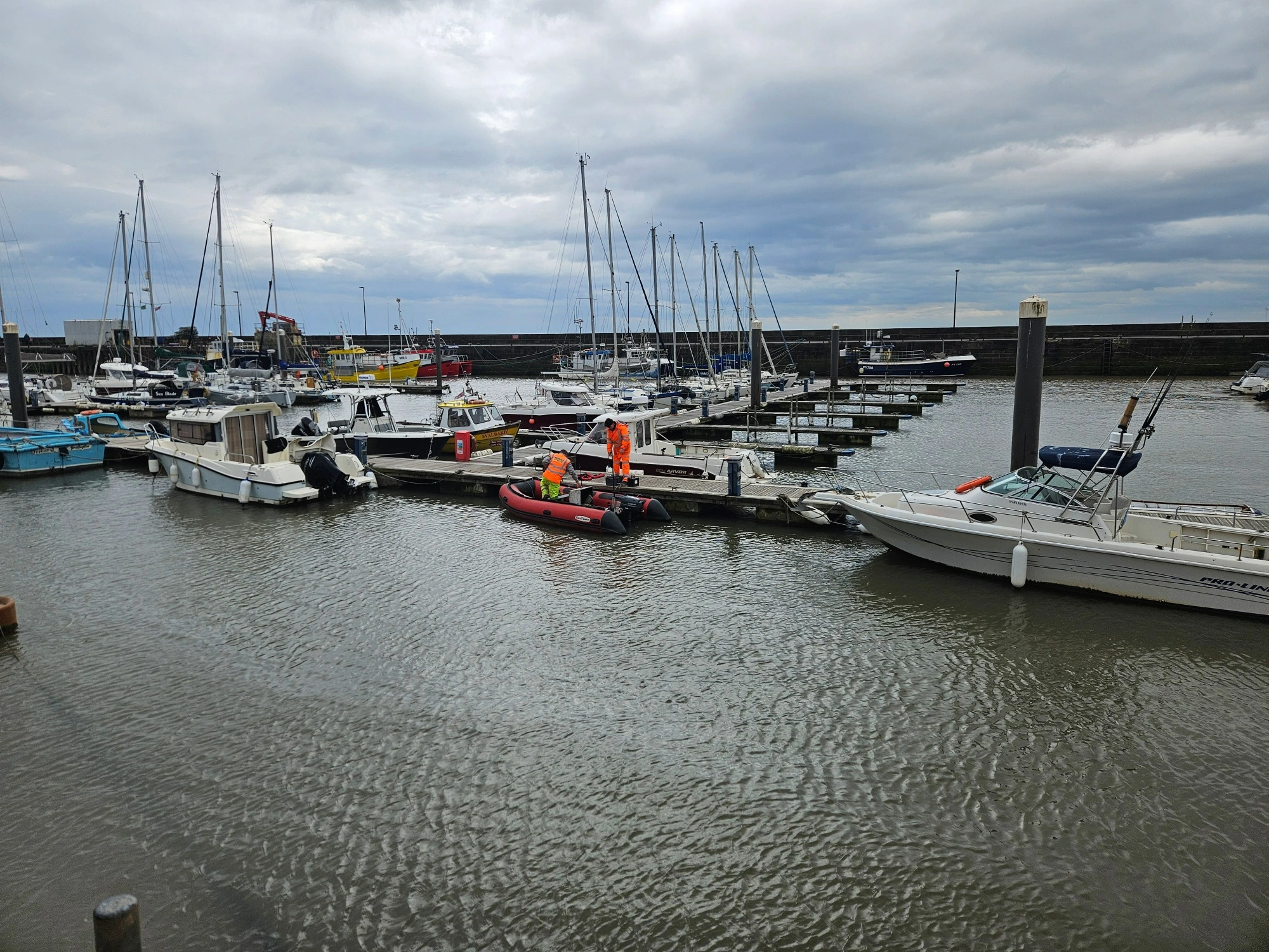 MHLS-bridlington-harbour-case-study (1)-4 MHLS land surveyors at bridlington harbour on a cloudy day surrounded by boats.